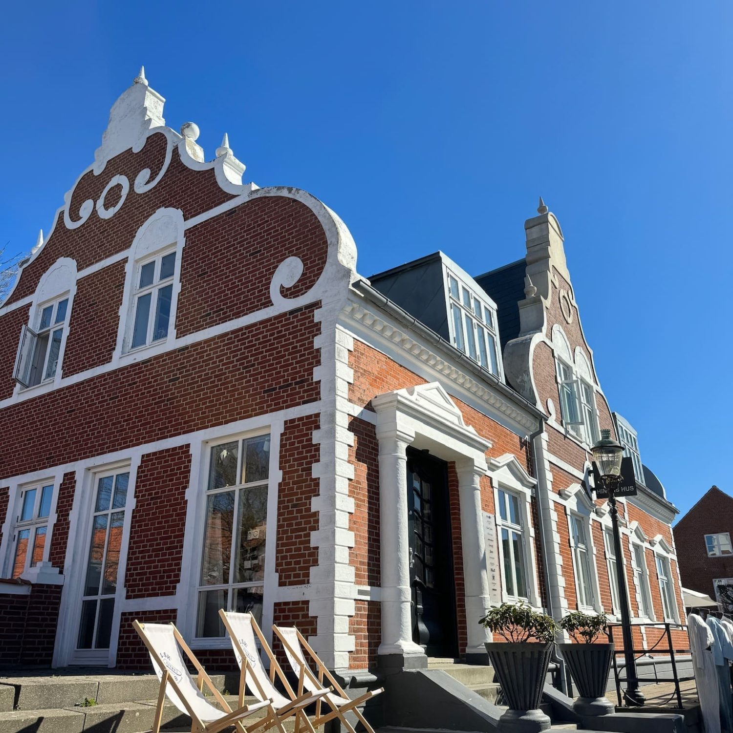 Hinges Hus i Ringkøbing, en smuk bygning kendt som Lille Rosenborg, med stole foran.